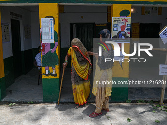 An elderly woman is walking out of the polling station after casting her vote during the third phase of the Indian General Elections in Hath...