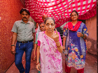 Voters are showing marks of indelible ink after casting their votes at a polling booth during the 3rd Phase of the India General Elections-2...