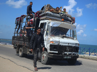 Displaced Palestinians are arriving with their belongings to set up tents on a beach near Deir el-Balah, in the central Gaza Strip, on May 7...