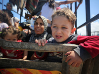Displaced Palestinians are arriving with their belongings to set up tents on a beach near Deir el-Balah, in the central Gaza Strip, on May 7...