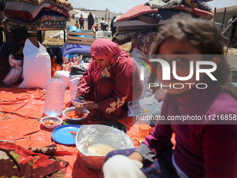 Displaced Palestinians are preparing a meal on a beach near Deir el-Balah, in the central Gaza Strip, on May 7, 2024, amid the ongoing confl...
