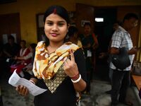 A woman is showing her ink-marked finger after casting her ballot at a polling station during the third phase of voting in India's general e...