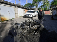 A man is standing by a fragment of a destroyed car on the premises of a garage cooperative after a massive Russian missile and drone attack...