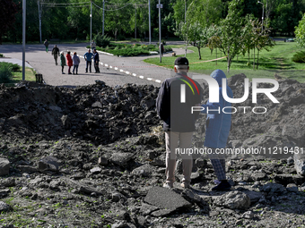 A man and a woman are standing by a crater after a massive Russian missile and drone attack during the night in Zaporizhzhia, southeastern U...