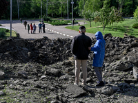 A man and a woman are standing by a crater after a massive Russian missile and drone attack during the night in Zaporizhzhia, southeastern U...