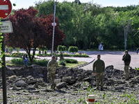 Servicemen are standing by a crater following a massive Russian missile and drone attack at night in Zaporizhzhia, Ukraine, on May 8, 2024....