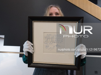 LONDON, UNITED KINGDOM - MAY 08, 2024: A staff member holds a famous napkin on which the commitment of a contract was written by Carles Rexa...