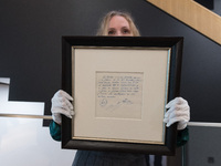 LONDON, UNITED KINGDOM - MAY 08, 2024: A staff member holds a famous napkin on which the commitment of a contract was written by Carles Rexa...