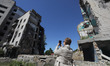 A member of a foreign delegation is taking a picture of an apartment building damaged by R...