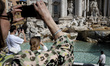 A tourist is posing for photos in front of the Trevi Fountain, which is currently without...