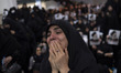 A veiled Iranian woman is mourning while participating in a farewell ceremony with the bod...