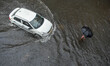 People are making their way through a flooded street after the storm in Kolkata, India, on...