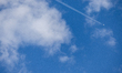 The contrail of an airplane is seen between the clouds in San Candido, Italy, on May 26, 2...