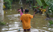 People are going to houses through flood water in Kelaniya, Sri Lanka, on June 2, 2024. 