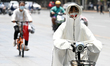 Citizens are wearing sunscreen clothes and riding in high temperatures in Handan, China, o...