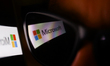 Microsoft logo displayed on a phone screen and reflected on sunglasses is seen in this ill...