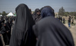 A veiled woman is looking on while participating in a religious festival to commemorate As...
