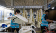 Workers are producing seats ordered by NIO on an assembly line at a workshop of a seating...