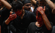 Shiite Muslims are hitting themselves on their heads as they bleed during a procession to...