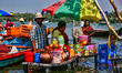 A woman is preparing snacks at a small snack stand in the water along Sambranikodi Island...