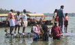 Indian tourists are standing on a small floating pier at Sambranikodi Island in Kerala, In...