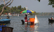 A woman is selling snacks at a small snack stand in the water along Sambranikodi Island in...