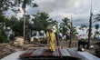 A woman is standing on her damaged house due to river erosion at Dohar, Dhaka, Bangladesh,...