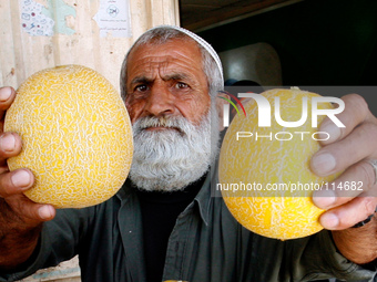 A Palestinian man displays melon in the shop in Rafah in the southern Gaza Strip on May 17, 2014. (
