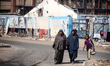 Displaced Palestinians are walking near their tents at a makeshift displacement camp set u...