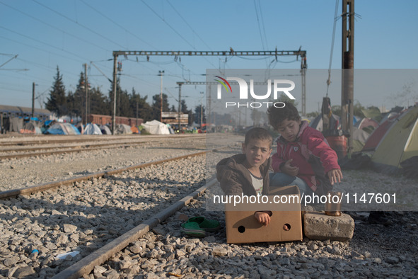 Kids playing with a box early in the morning in Idomeni camp on April 6, 2016. 