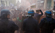 People dance amid smoke in front of riot police at the end of a protest against the El-Kho...