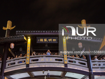 A large number of tourists watch a light show at the ancient Drum Tower in Ningbo, Zhejiang province, China, on the evening of August 24, 20... by Costfoto/NurPhoto