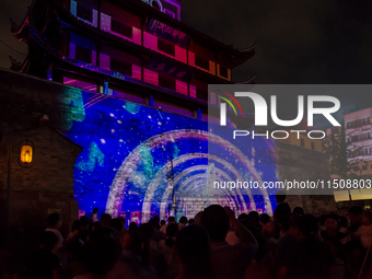 A large number of tourists watch a light show at the ancient Drum Tower in Ningbo, Zhejiang province, China, on the evening of August 24, 20... by Costfoto/NurPhoto