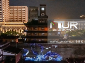 A large number of tourists watch a light show at the ancient Drum Tower in Ningbo, Zhejiang province, China, on the evening of August 24, 20... by Costfoto/NurPhoto