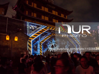 A large number of tourists watch a light show at the ancient Drum Tower in Ningbo, Zhejiang province, China, on the evening of August 24, 20... by Costfoto/NurPhoto