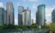 Pedestrians pass the Shanghai Tower, World Financial Center, and Jinmao Tower at Lujiazui...