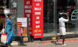 A man covers his head to protect himself from the hot sun while walking along the footpath...