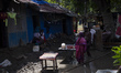 A flood-affected family places rice on a table to dry in the low sun in the Gopal area of...