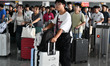 Passengers pass through the ticket gate at Fuyang West Railway Station in Fuyang, China, o...