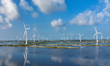 Wind turbines rotate in the wind on the coastal beaches of Yancheng City, Jiangsu Province...