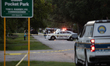 A crime scene unit and various police officials surround Bauer Pocket Park in City, Countr...