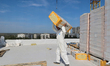 A construction worker restores a multi-storey residential building damaged by Russian shel...