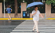 People travel in rain on a street in Shanghai, China, on September 15, 2024. 