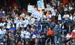 New York Mets fans hold up signs during the eighth inning of a baseball game between the P...