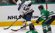 Hugh McGing #56 of the St. Louis Blues skates with control of the puck while defended by J...