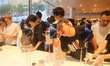 Customers experience Apple's new flagship mobile phone, the iPhone 16, at the largest Appl...