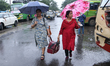 Women hold umbrellas as they walk in the monsoon rain in Kolkata, India, on September 26,...
