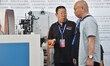 An exhibitor introduces production equipment to a buyer at the 17th China Handan (Yongnian...