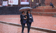 Nepali students wear umbrellas as they walk around Patan Durbar Square, a UNESCO World Her...