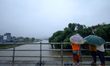 People watch the swollen Bagmati River from a bridge in Kathmandu, Nepal, on September 27,...